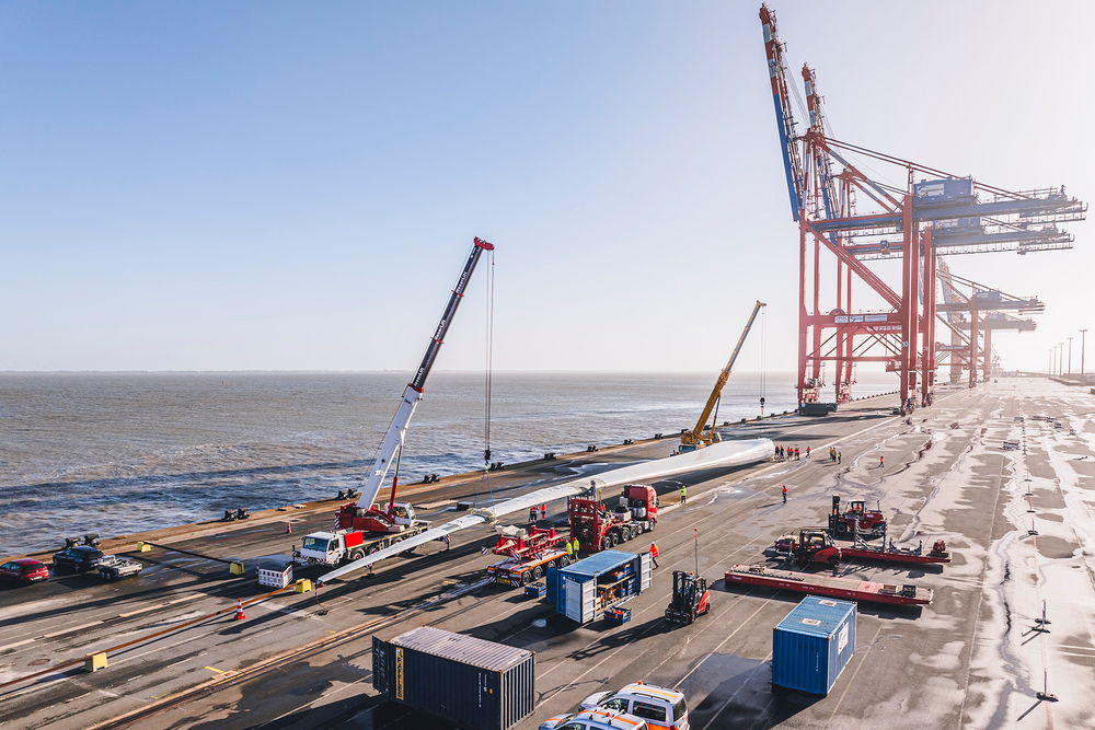 Schwertransportfahrzeug von DOLL für Windkraftanlagen am Hafen bei Sonnenuntergang